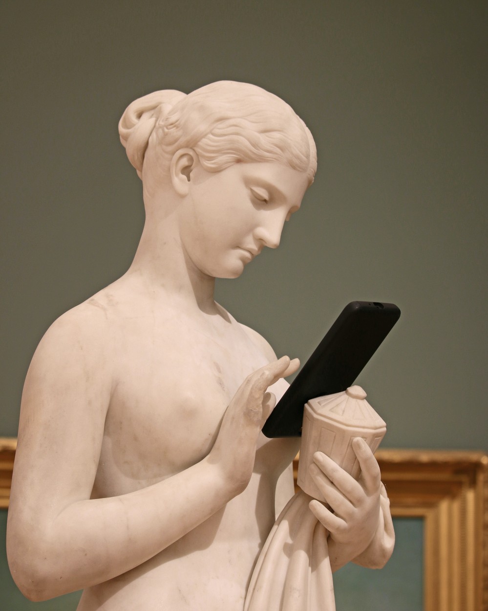 Eine weiße Statue hält ein Smartphone
