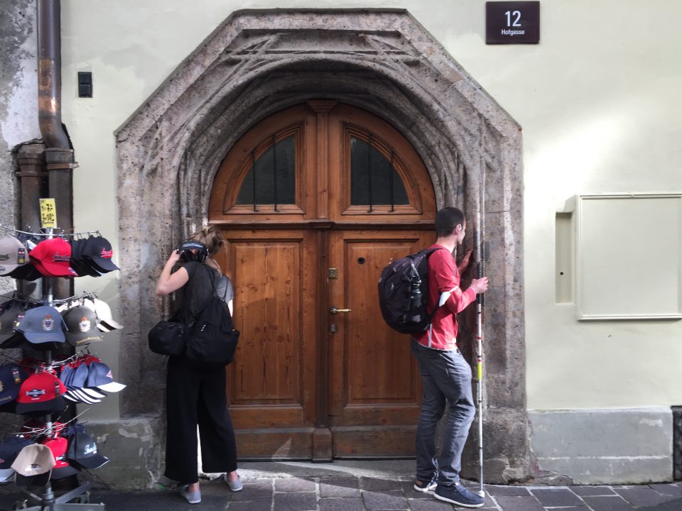 Pawel und Hemma stehen rechts und links beim Flüsterbogen in der Innsbrucker Altstadt und flüstern und hören.